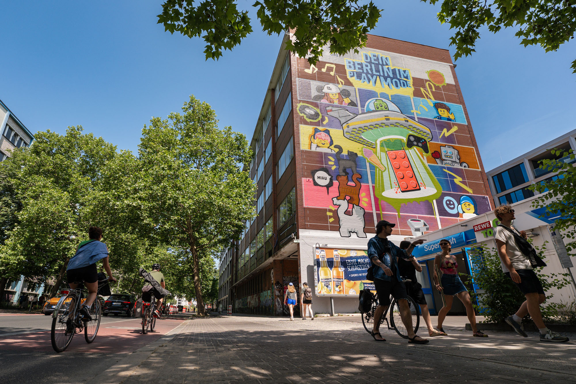 Farbenfrohes Lego Wandgemälde am Berliner Moritzplatz, zeigt ein spielerisches Mural mit Ufo, Lego-Steinen und Comicfiguren, umgesetzt von CONCRETE CANDY als Urban Art Projekt in Berlin.