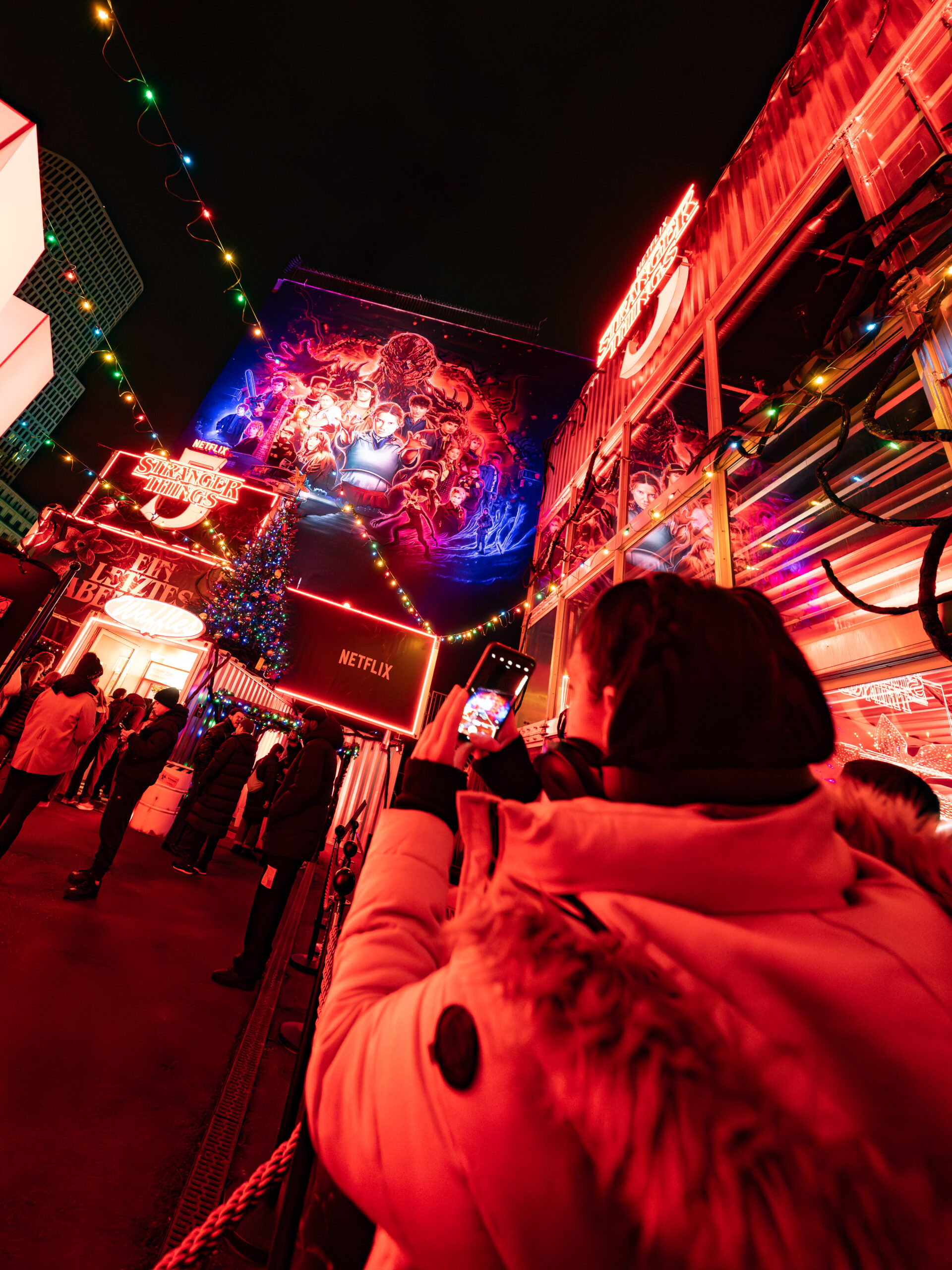 Eine Person macht Fotos in der Warteschlange auf dem WEihnachtsmarkt