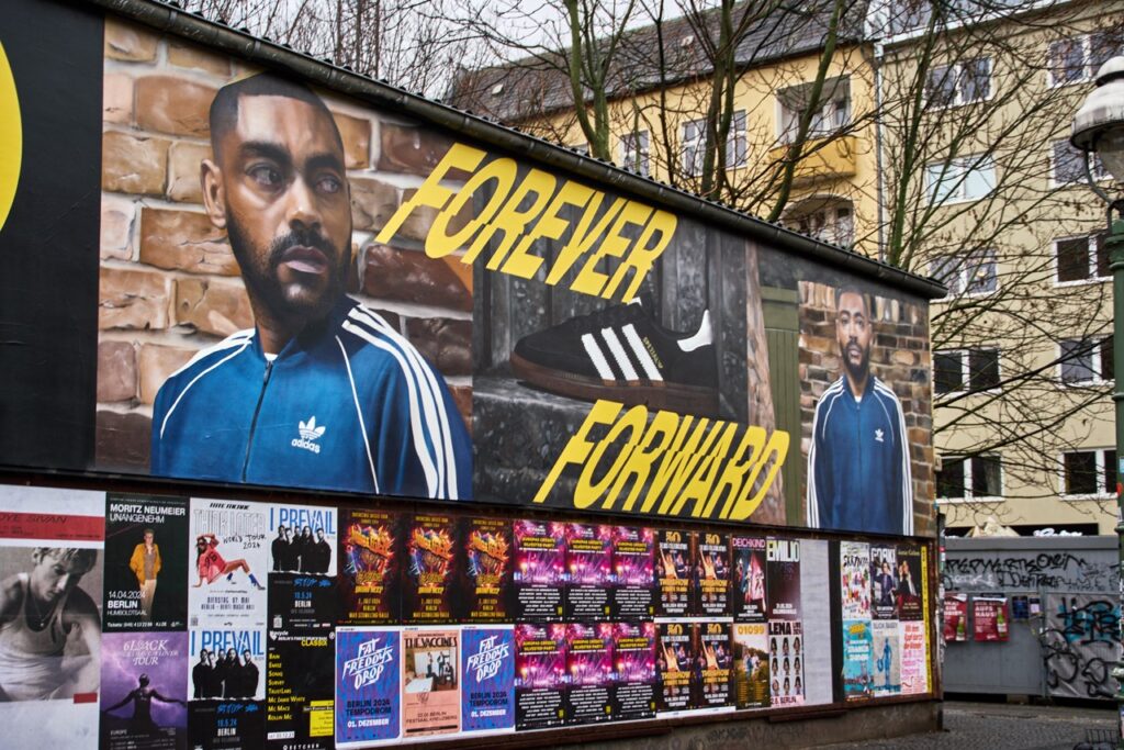 Großformatiges Street-Art-Mural für JD Sports am L.U.X. in Berlin-Kreuzberg mit Model in Adidas-Trackjacket und dem Schriftzug „Forever Forward“.