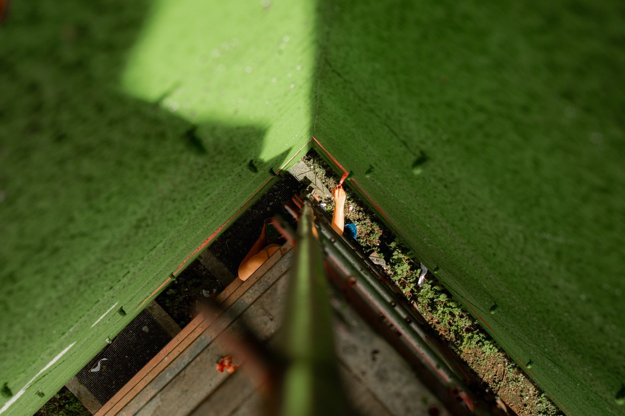 Dramatische Perspektive entlang eines Gerüsts auf die grün gestrichene Wandfläche des S-Bahn München Murals während der Entstehung.
