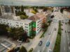 Drohnenaufnahme eines großformatigen S-Bahn München Murals an einem Wohngebäude entlang der stark befahrenen Tegernseer Landstraße in München.