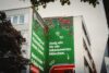 Detailaufnahme des fertigen S-Bahn München Murals mit floralen Illustrationen, Typografie und gezeichnetem S-Bahn-Zug an einer Hausfassade.