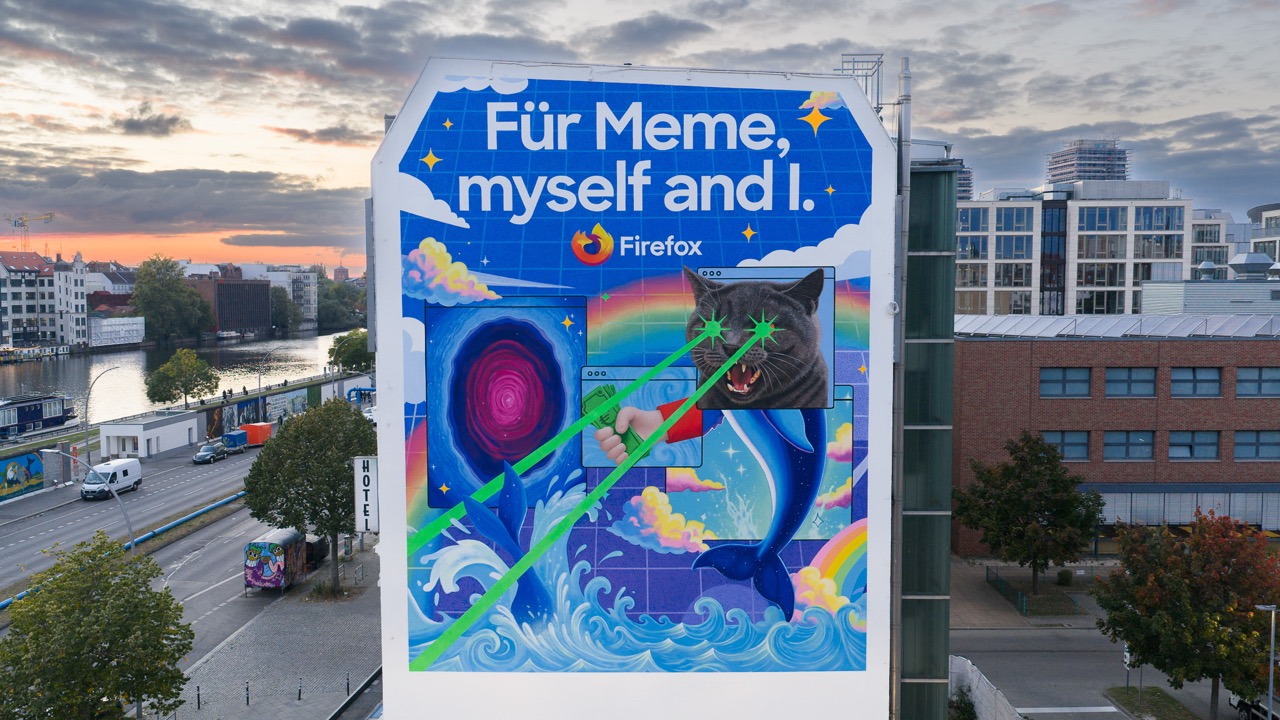 Großformatiges Firefox Mural mit dem Schriftzug „Für Meme, myself and I“ auf einer Gebäudefassade in Berlin, kombiniert mit surrealen Motiven wie Katze, Delfin, Wellen und digitalen Elementen.