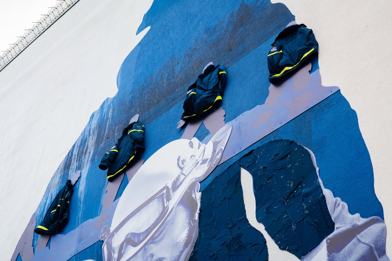 Detailaufnahme eines Murals mit angebrachten THW-Uniformen als plastisches Element auf der Wand.
