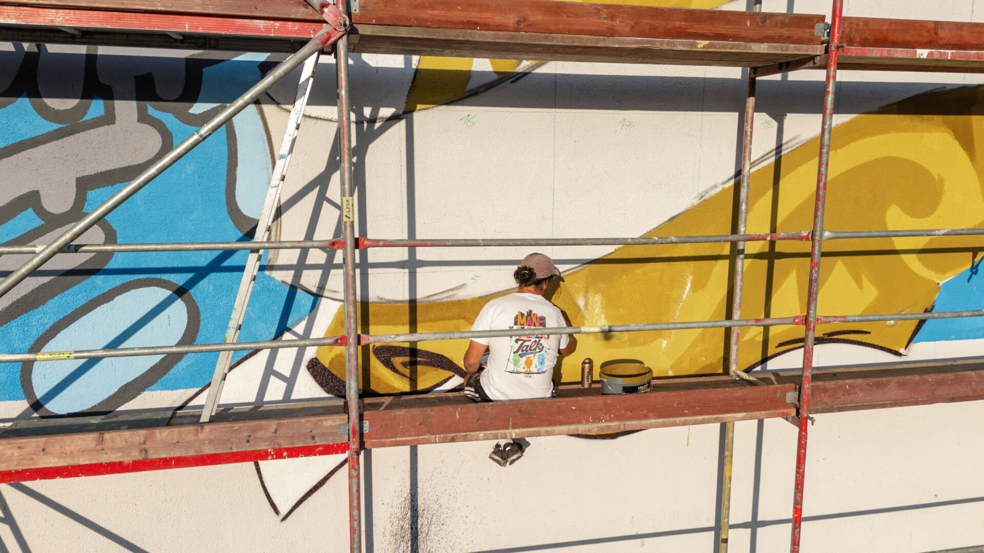 Künstler arbeitet auf einem Gerüst an einem Hertha-BSC-Wandbild während des Entstehungsprozesses.