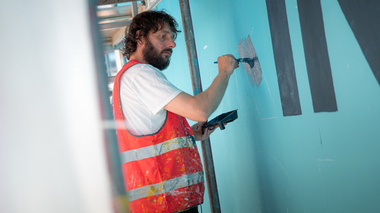 Street-Artist arbeitet am großformatigen Rexona Mural in Berlin während der Umsetzung auf dem Gerüst.