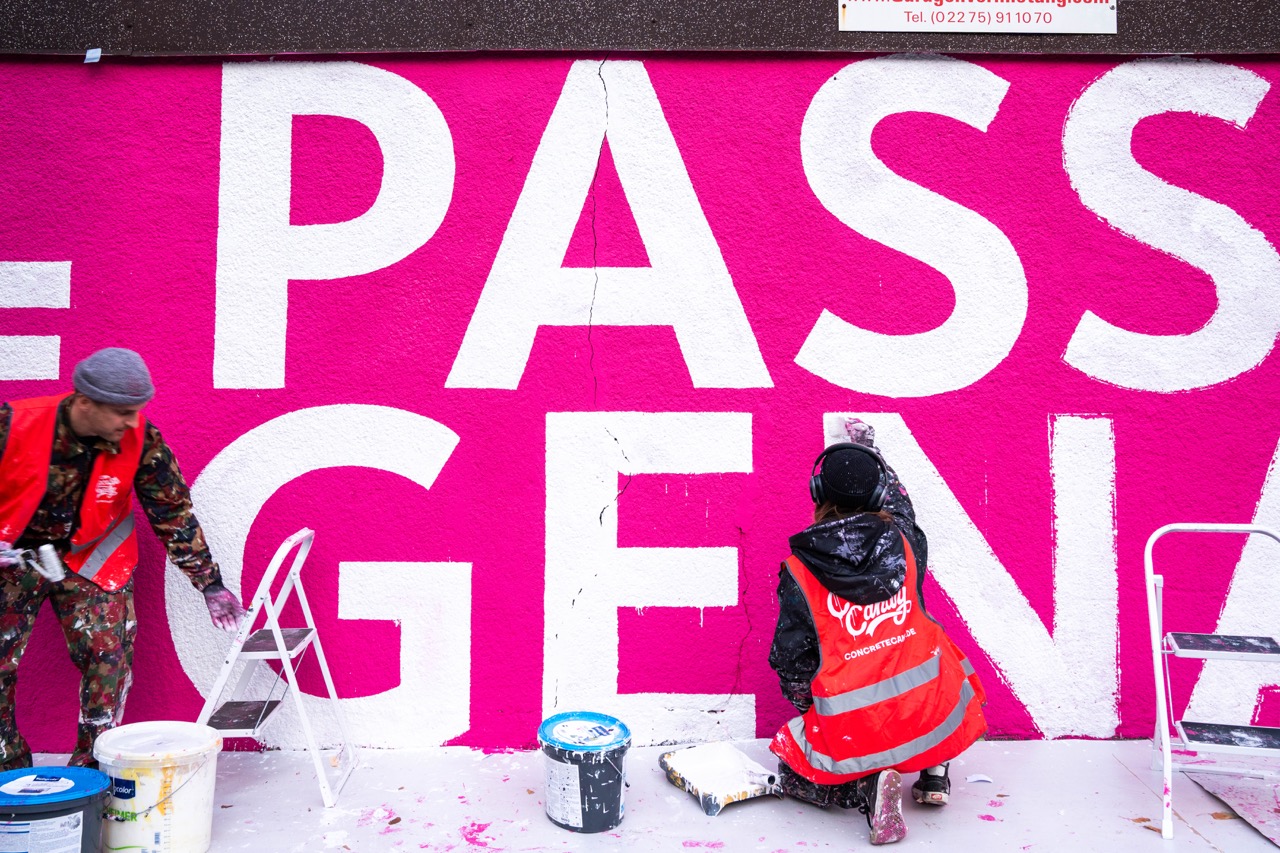 Zwei Künstler in Warnwesten arbeiten gemeinsam an einem großflächigen 1LIVE Mural in Gelsenkirchen
