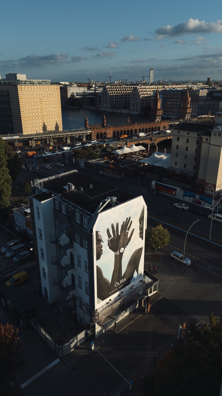 Weitwinkel-Drohnenaufnahme des Murals am East Side Hotel mit Blick über die Spree und die Oberbaumbrücke in Berlin.