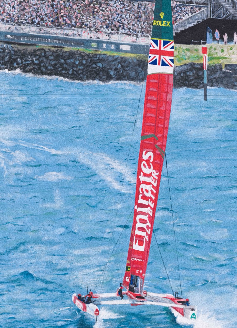 Close-up eines Rennkatamarans mit Emirates Branding, der mit hoher Geschwindigkeit über das Wasser schneidet.