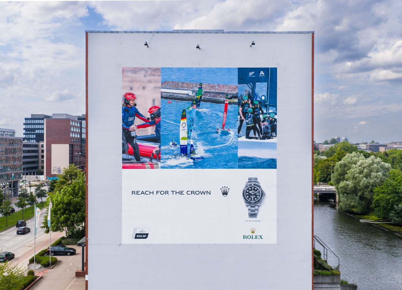 Weitwinkelaufnahme des Murals im urbanen Kontext mit umliegenden Gebäuden und Wasserlage in Hamburg.