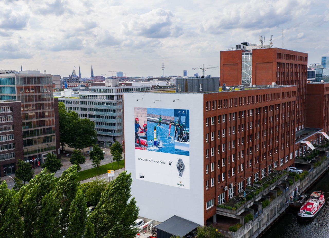 Unterer Bereich des Murals mit Claim „Reach for the Crown“, Rolex Logo und Abbildung der Yacht-Master Uhr.