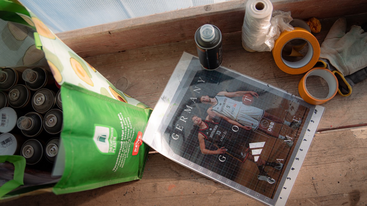 Motivvorlage des adidas Basketball-Murals mit den Wagner-Brüdern zwischen Spraydosen und Arbeitsmaterial auf dem Gerüst.