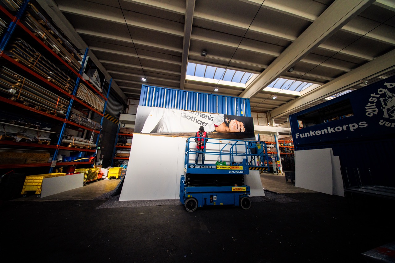 Großformatiges Muralmodul in der Werkhalle während der Bemalung mit Hebebühne und vorbereiteten Installationselementen.