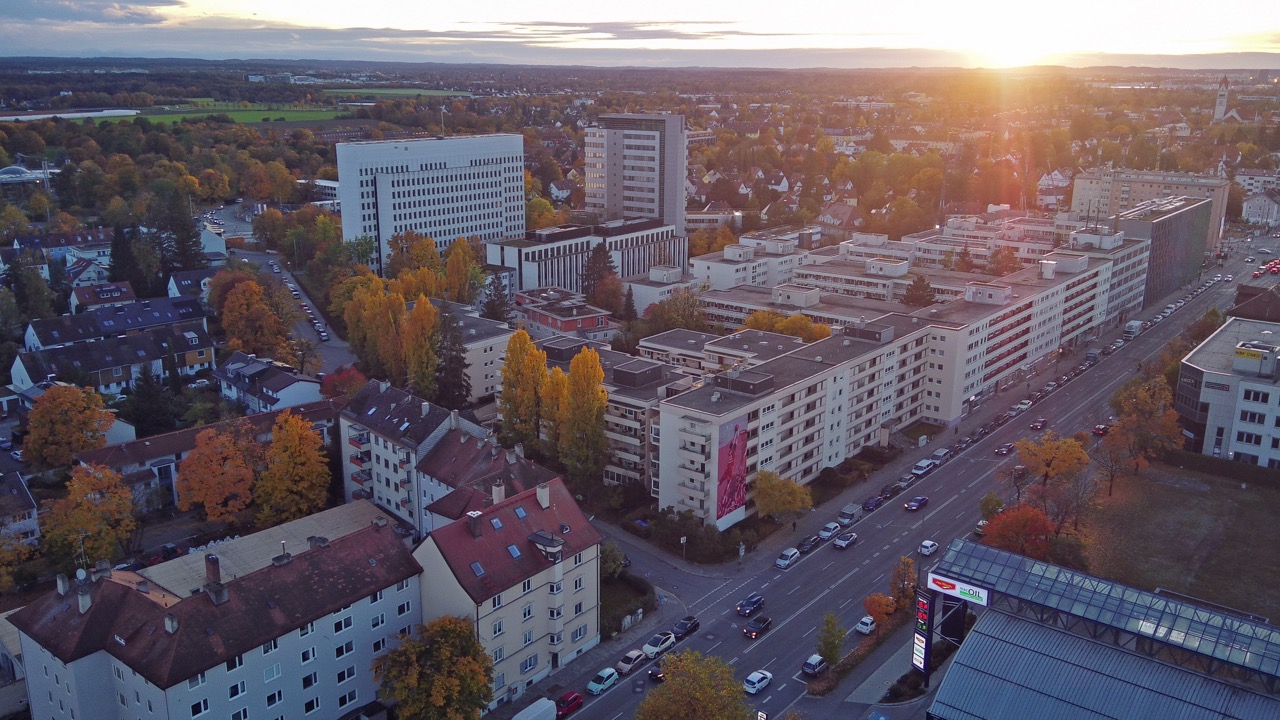 Luftaufnahme des FC Bayern Basketball Murals an einer Gebäudefassade in München mit tief stehender Abendsonne und urbanem Umfeld.