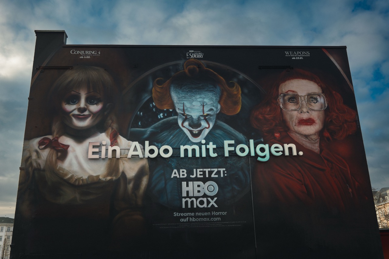 Frontale Tagesansicht des großformatigen HBO-Max-Murals „Ein Abo mit Folgen“ mit Horrorfiguren und 3D-Schriftzug.