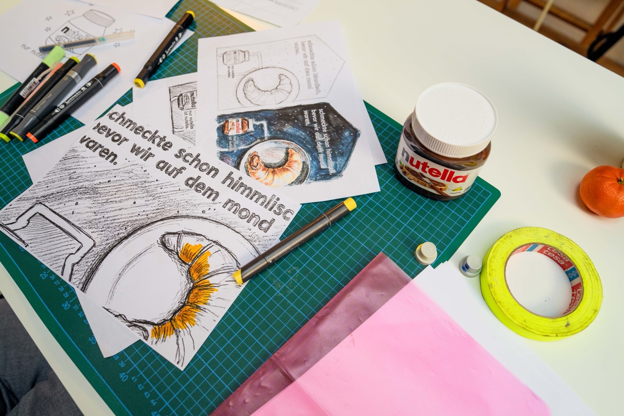 Erste handgezeichnete Entwürfe des Nutella MOTION MURAL® mit Croissant-Motiv, Claim und Kompositionsstudien.