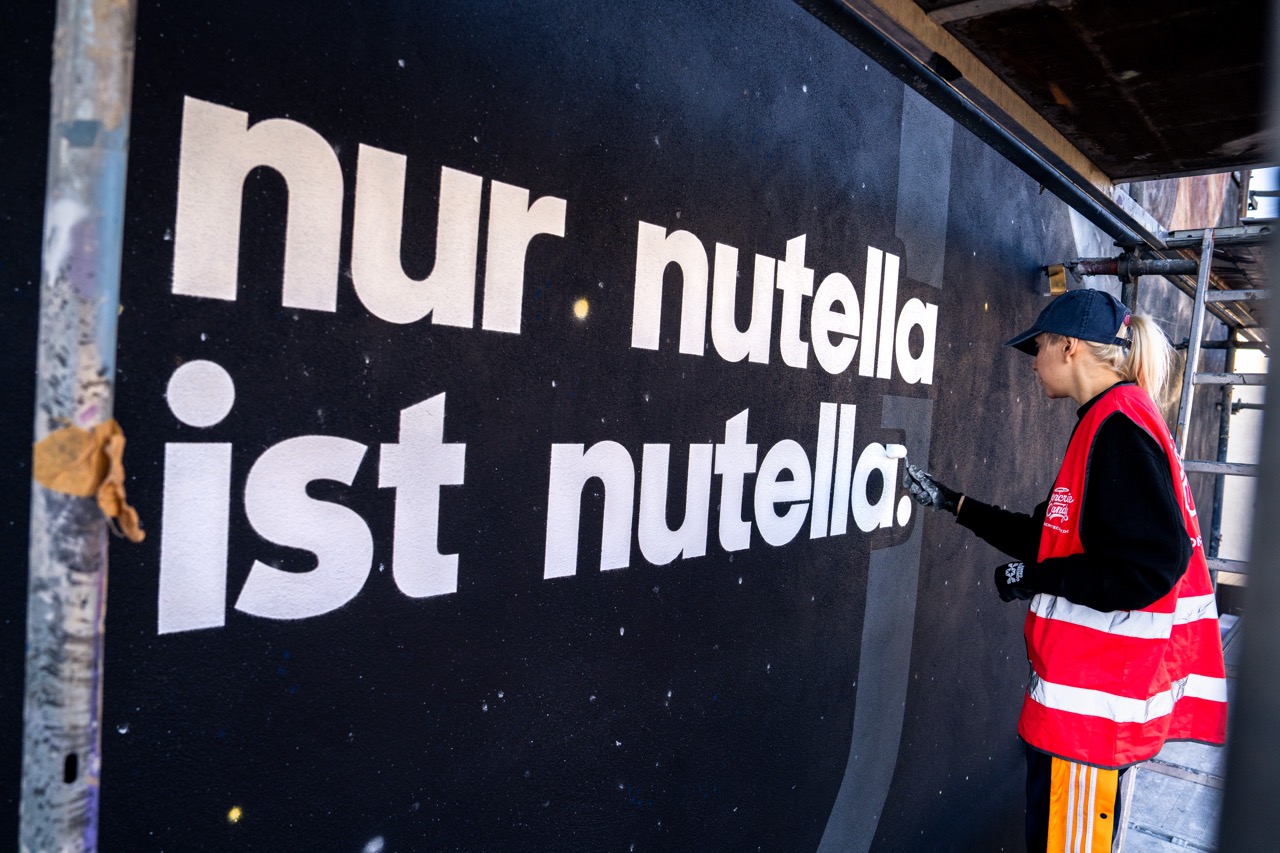Feinarbeiten am Schriftzug des Nutella MOTION MURAL® mit Pinsel und Spraytechnik.