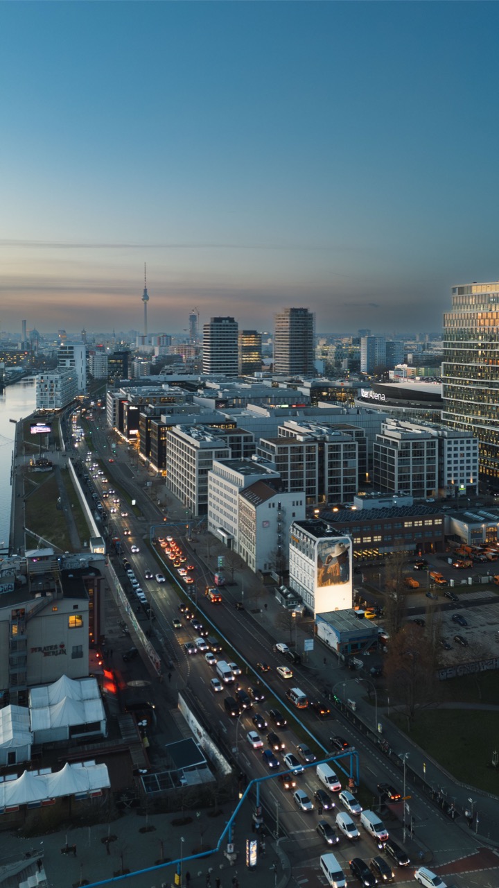 Weitwinkelaufnahme der Berliner Skyline mit beleuchtetem Ralph-Lauren-Mural an einer markanten Hausfassade bei Abenddämmerung.