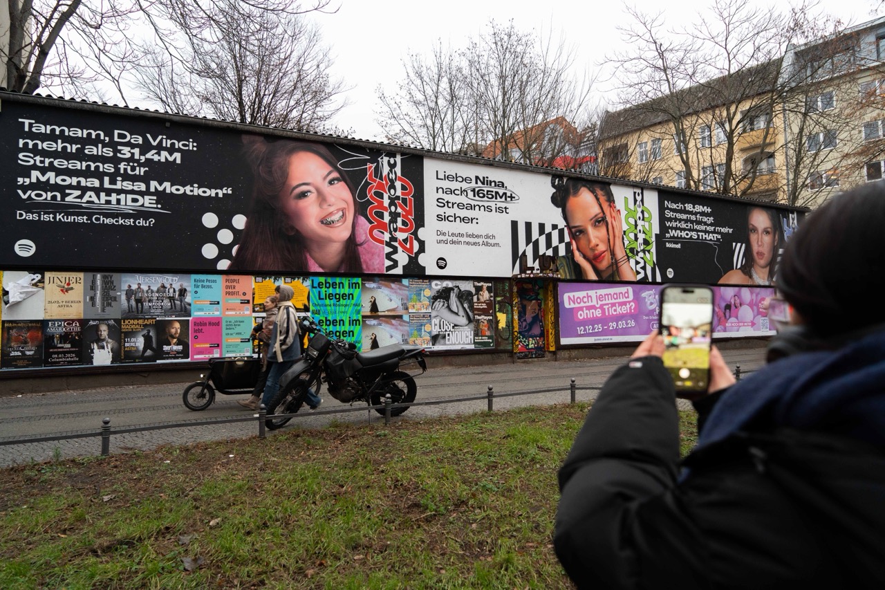 Großformatige Spotify Wrapped Installation mit deutschen Musikstars an einer Berliner Häuserwand, fotografiert von einer Passantin.